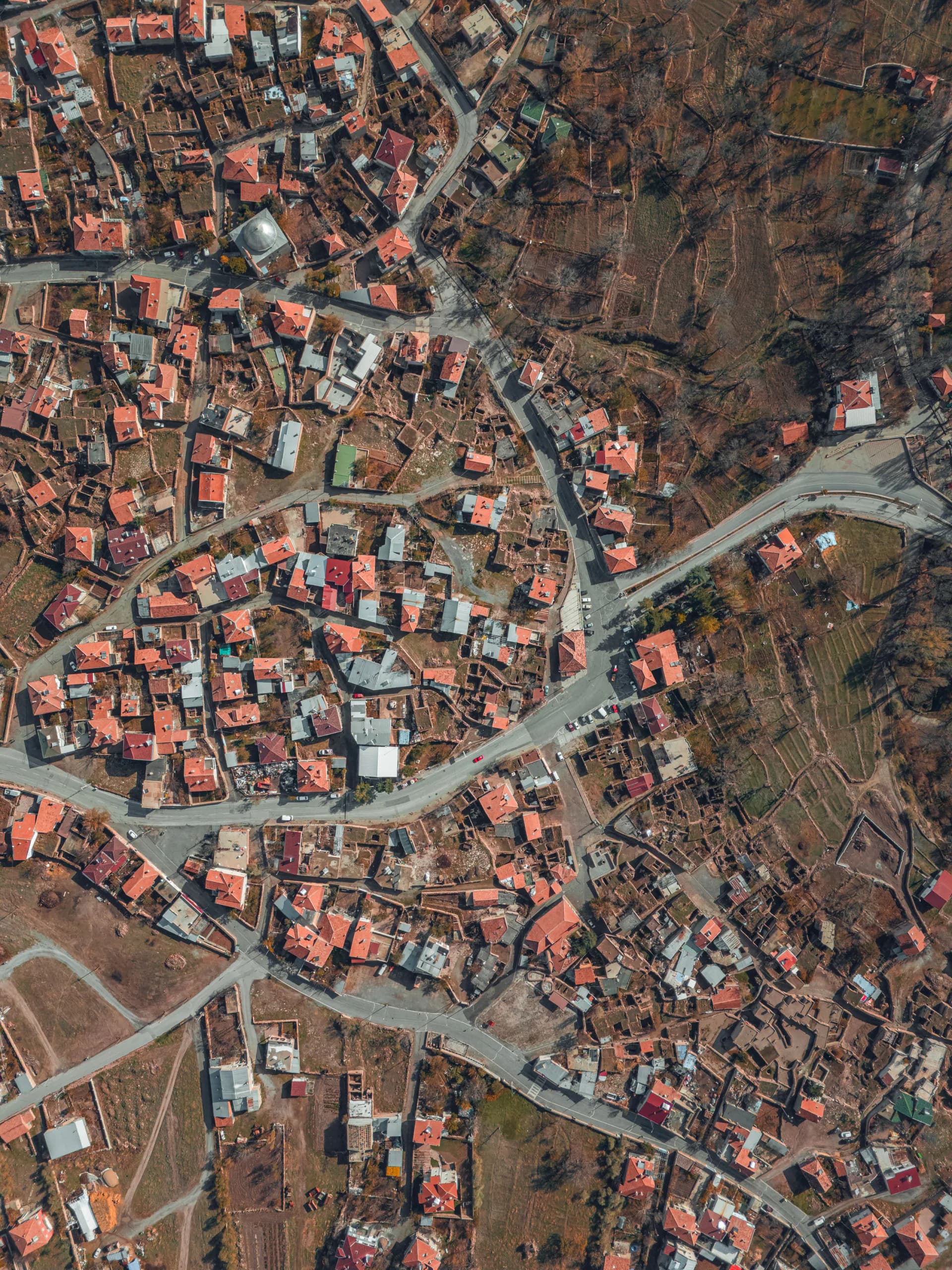 Aerial view looking straight down on a hillside settlement whose streets follow the slope in an irregular, branching pattern.